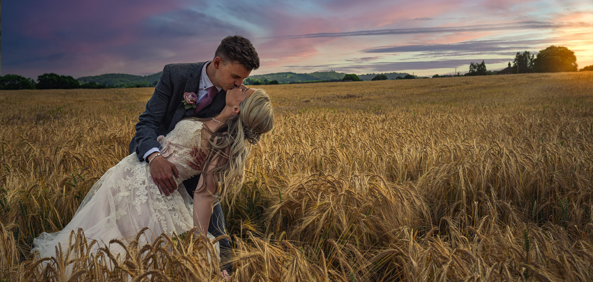 bride and groom posed in a corn field kissing