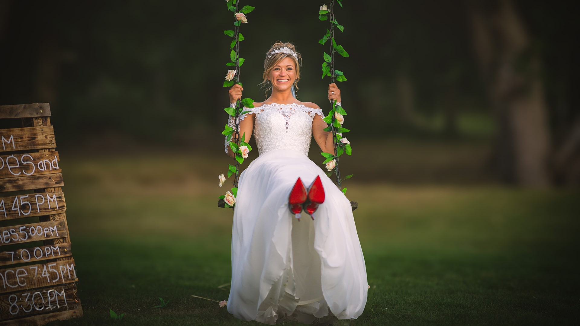 bride in her drerss on a swing with red shoes on