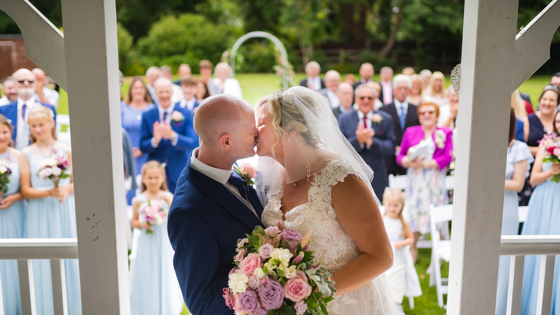 bride and groom kissing in front of people