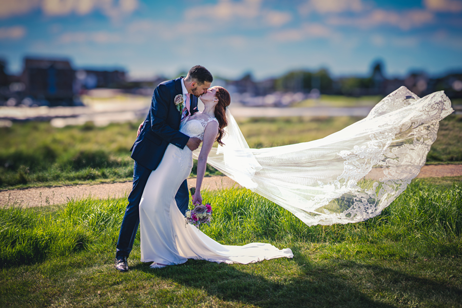 wedding couple kissing and the veil flowing in the wind